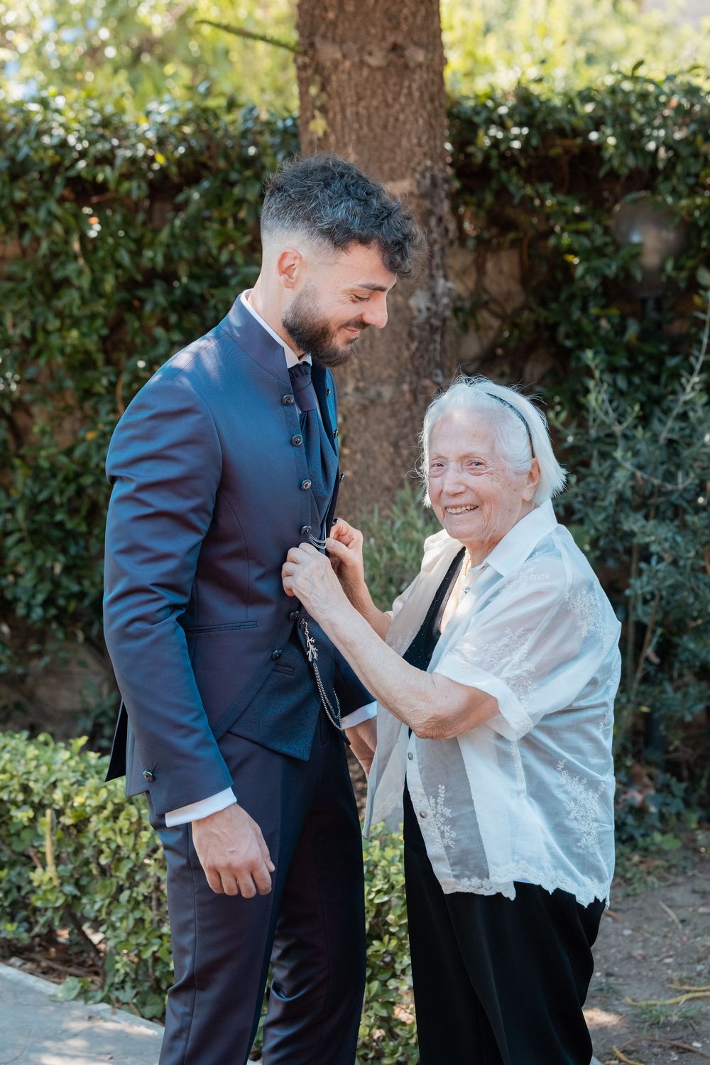 Emotional wedding moment captured in a garden setting with guests sharing joyful dance moves.