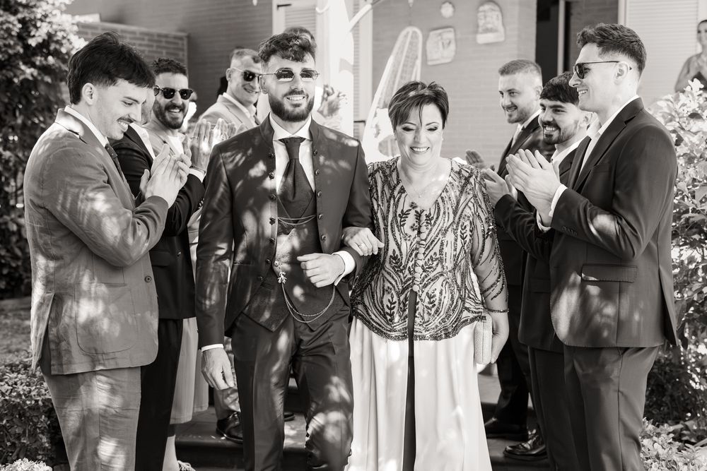 Wedding party laughs and celebrates together during photos at an elegant indoor venue.