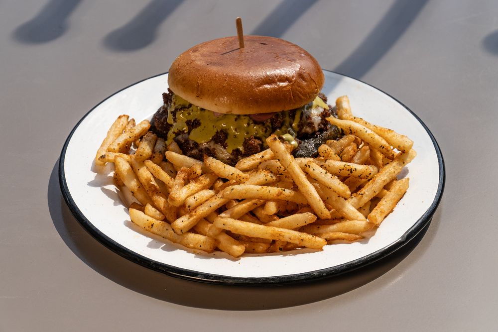 Classic diner plate featuring a burger and golden french fries on white dishes.