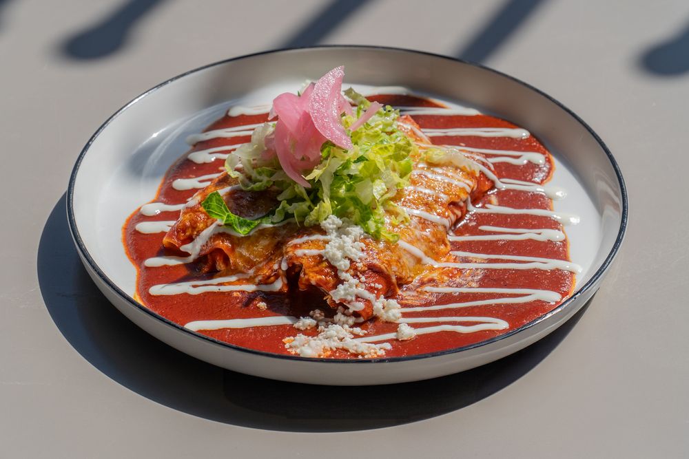 Elegant plated dishes with colorful sauces and garnishes arranged in a progressive sequence on dark plates.