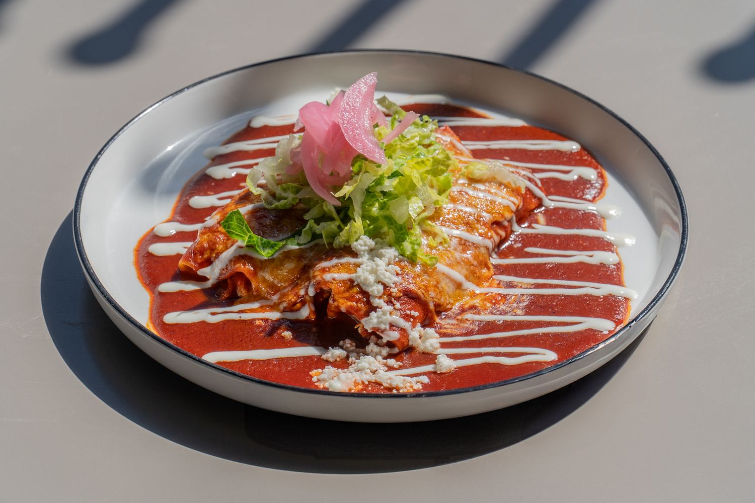 Elegant plated dishes with colorful sauces and garnishes arranged in a progressive sequence on dark plates.