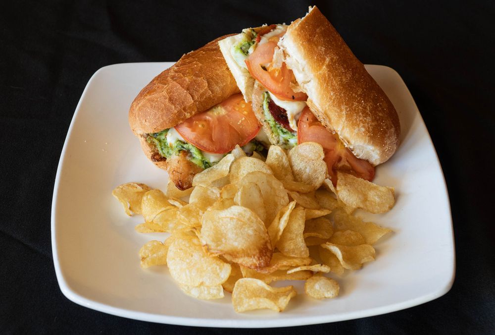 Appetizer platter with potato chips and dipping sauce served on white rectangular plate.
