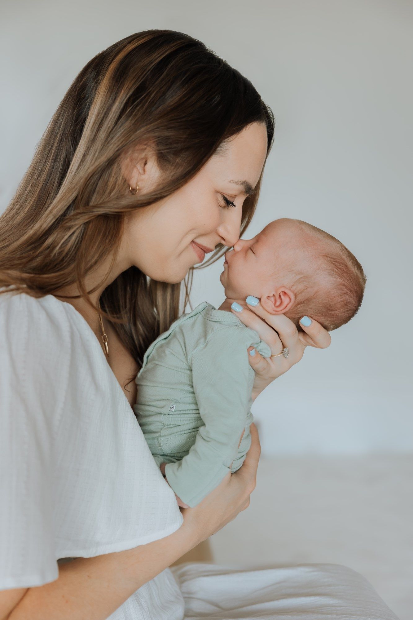 Tender newborn photography session showing intimate mother and baby moments.