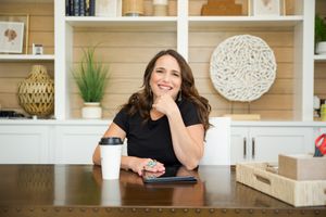Someone relaxes at a wood kitchen counter with coffee and enjoys a casual moment in a modern home interior.