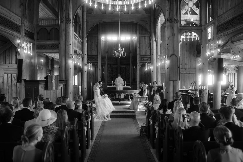 Black and white photograph of a church wedding ceremony with guests in pews.