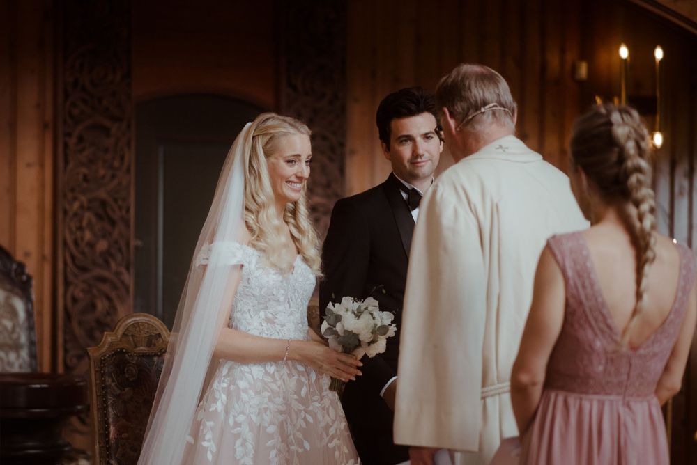 An elegant church wedding ceremony with a bride in a lace gown standing at the altar.