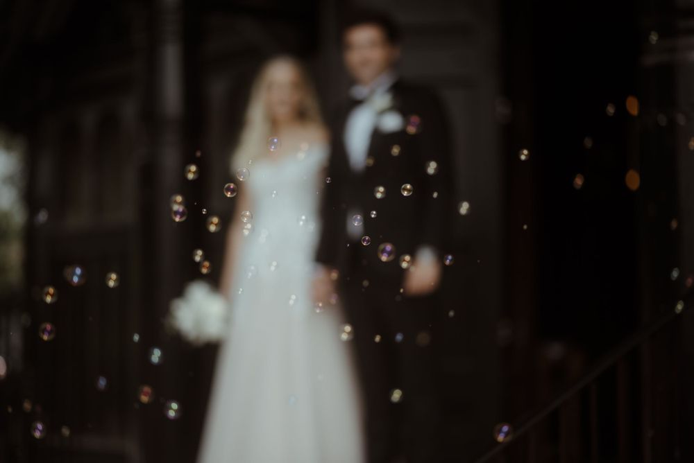 An artistic wedding photo with floating bubbles creating a dreamy atmosphere.