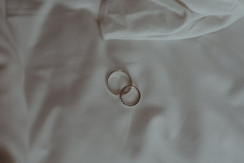 Two wedding rings placed on white fabric, captured from above.