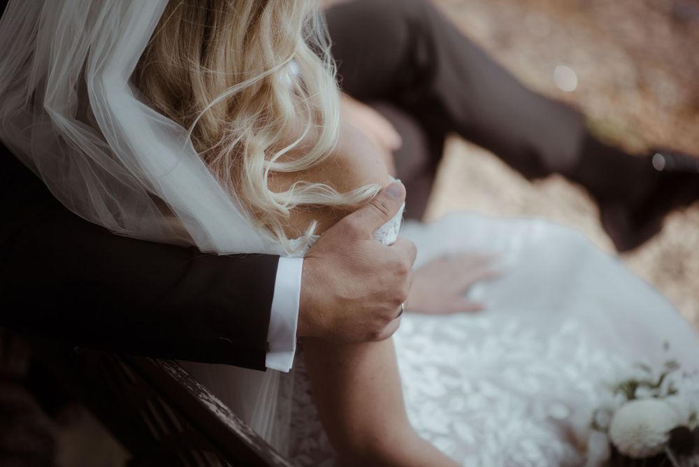 Close-up shot of wedding dress details with veil and formal attire.