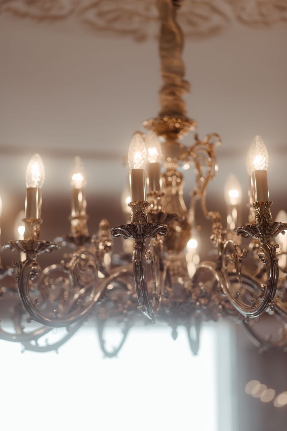 Close-up detail of a vintage crystal chandelier with glowing candle-style bulbs.