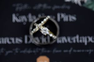 Elegant diamond wedding rings photographed on dark background with calligraphy text.
