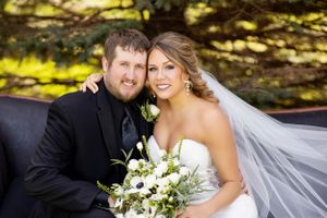 Wedding portrait under dappled sunlight with white floral bouquet.