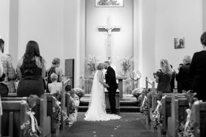 A black and white photograph of a traditional church wedding ceremony with guests in attendance.