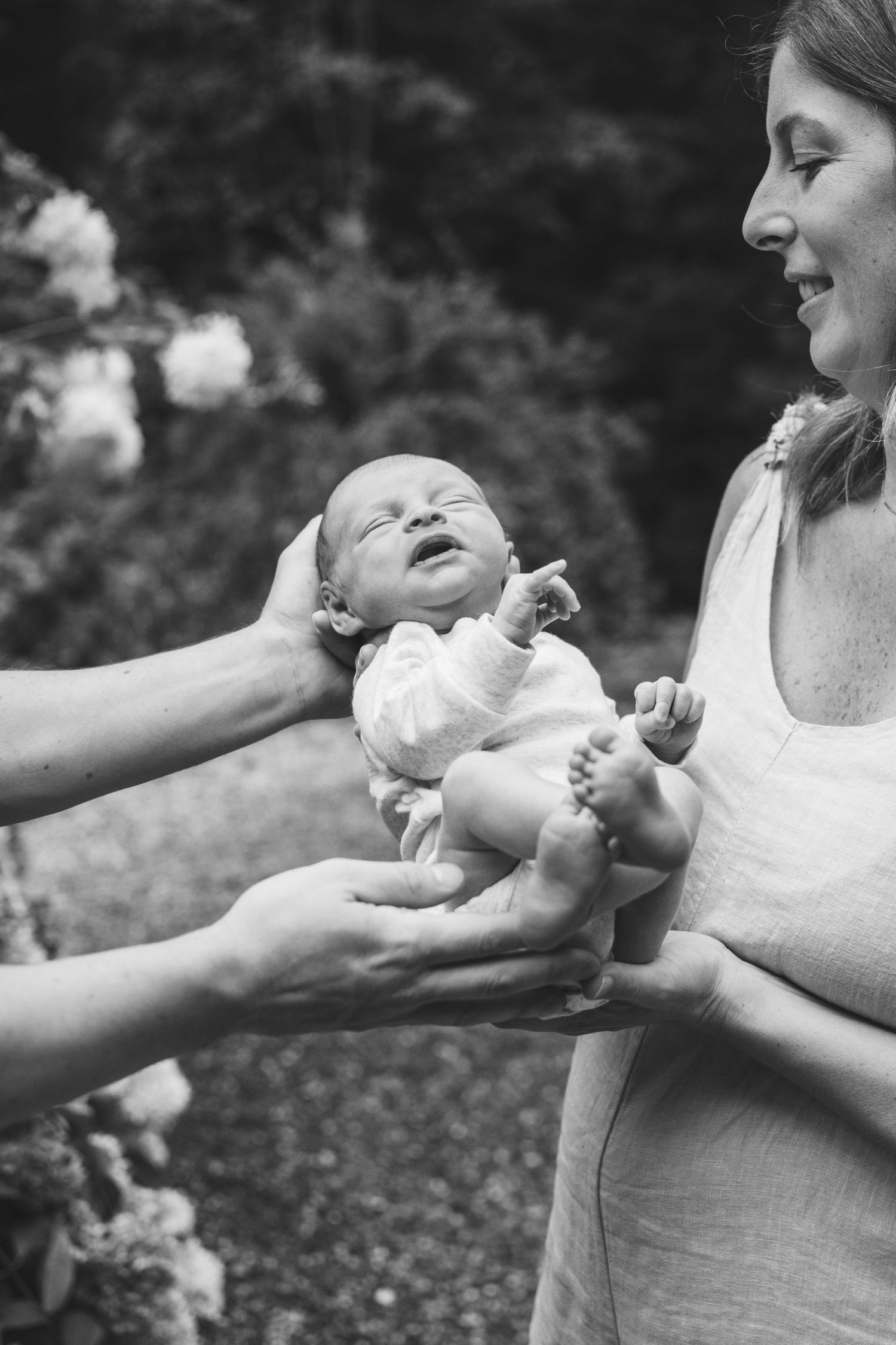 A black and white photo sequence shows a parent playing with a baby's feet in a tender moment outdoors.
