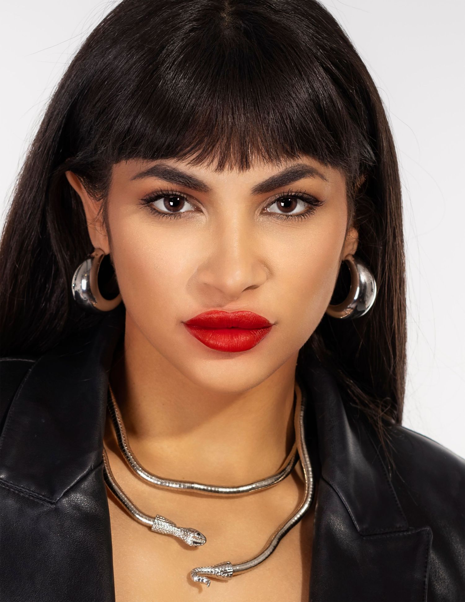 Glamour portrait with bold red lipstick and silver snake necklace against white background. Russian speaking portrait photographer.