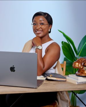 A lady seating on a desk with a laptop