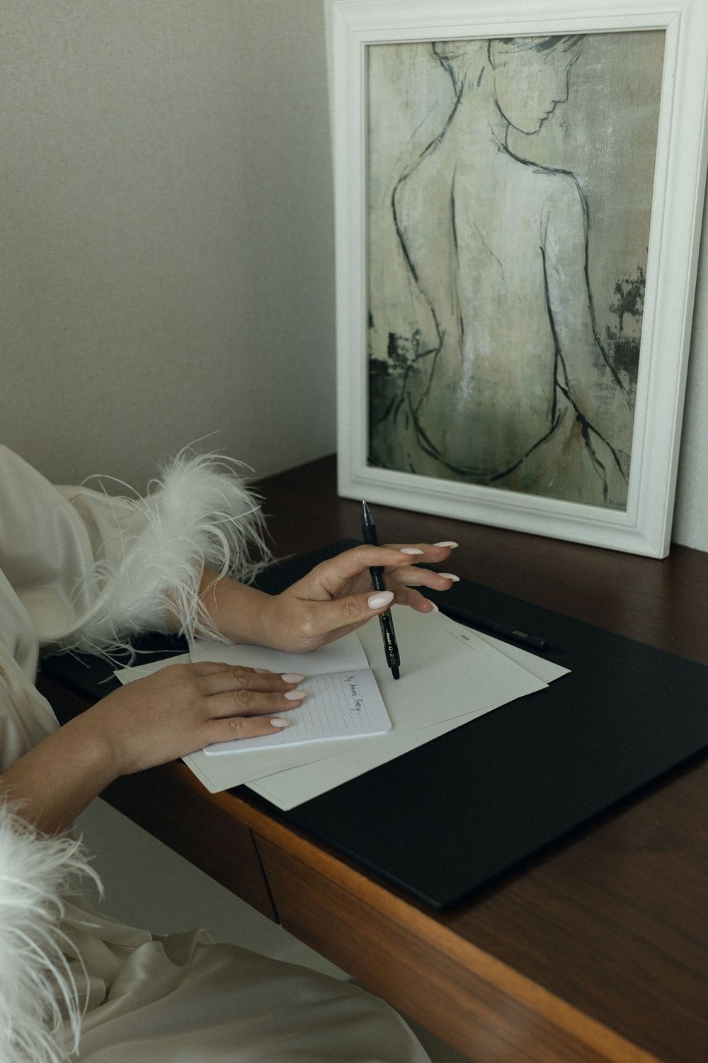 A hand arranges framed black and white figure sketches on a dark wooden surface in a sequential photo series.