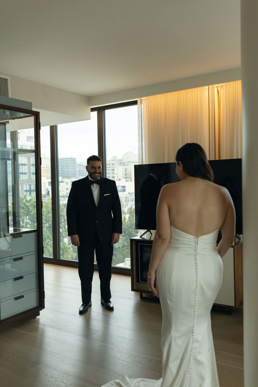 A tender moment captured in a modern apartment as newlyweds share their first look before the ceremony.