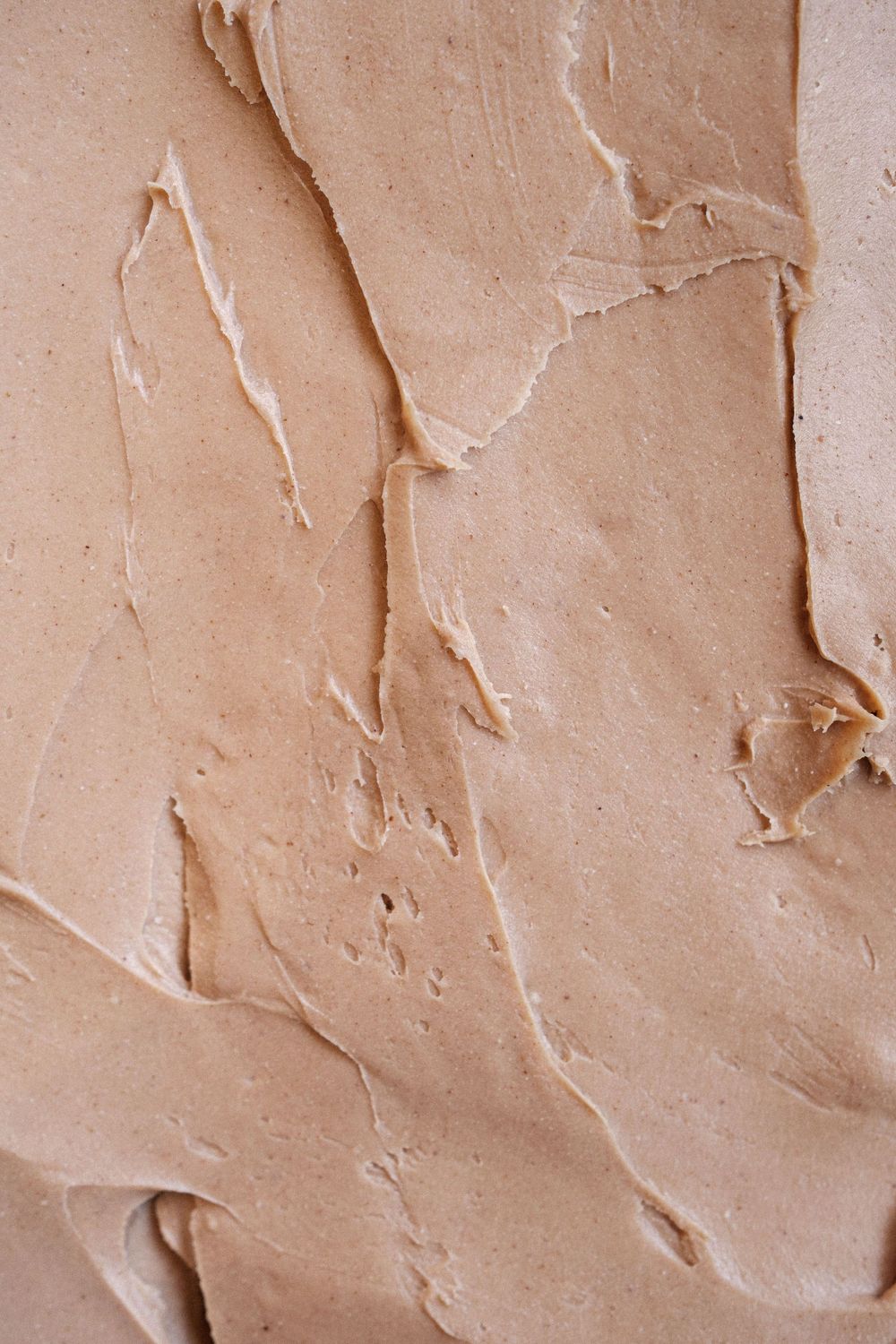 Textured beige pastry cream or mousse with natural swirls and folds.