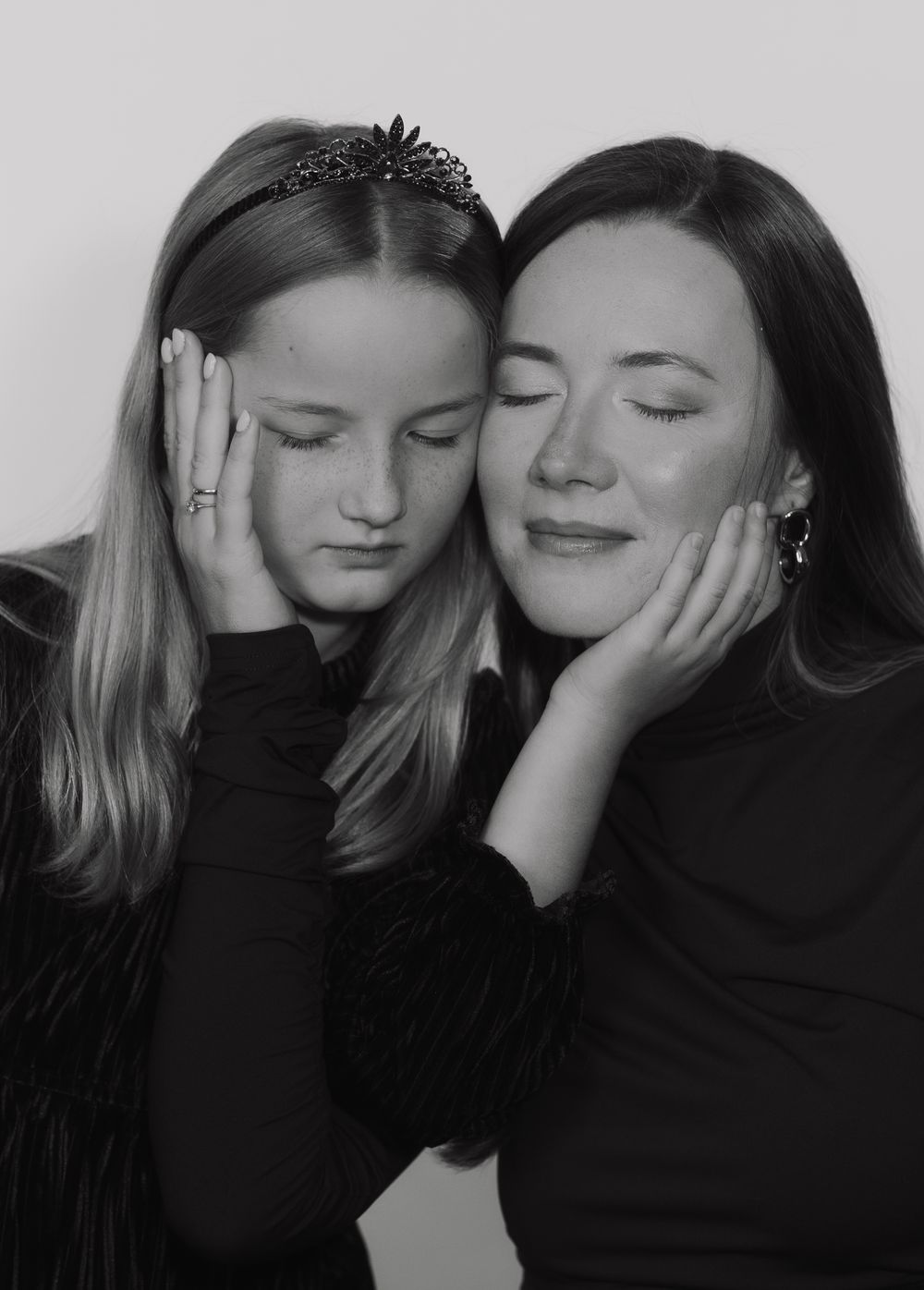 A black and white photo series showing four intimate moments between two people in dark clothing.
