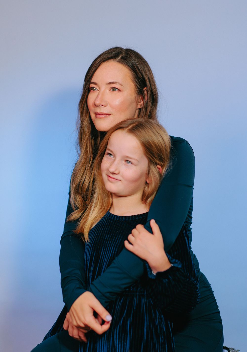 A series of fashion portraits showing a person in a dark top against a blue background posing with different expressions.