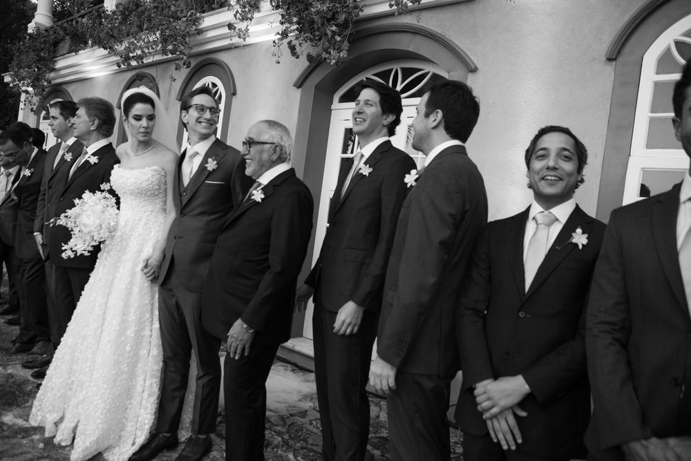 Black and white photo of a formal wedding party posing together in elegant attire.