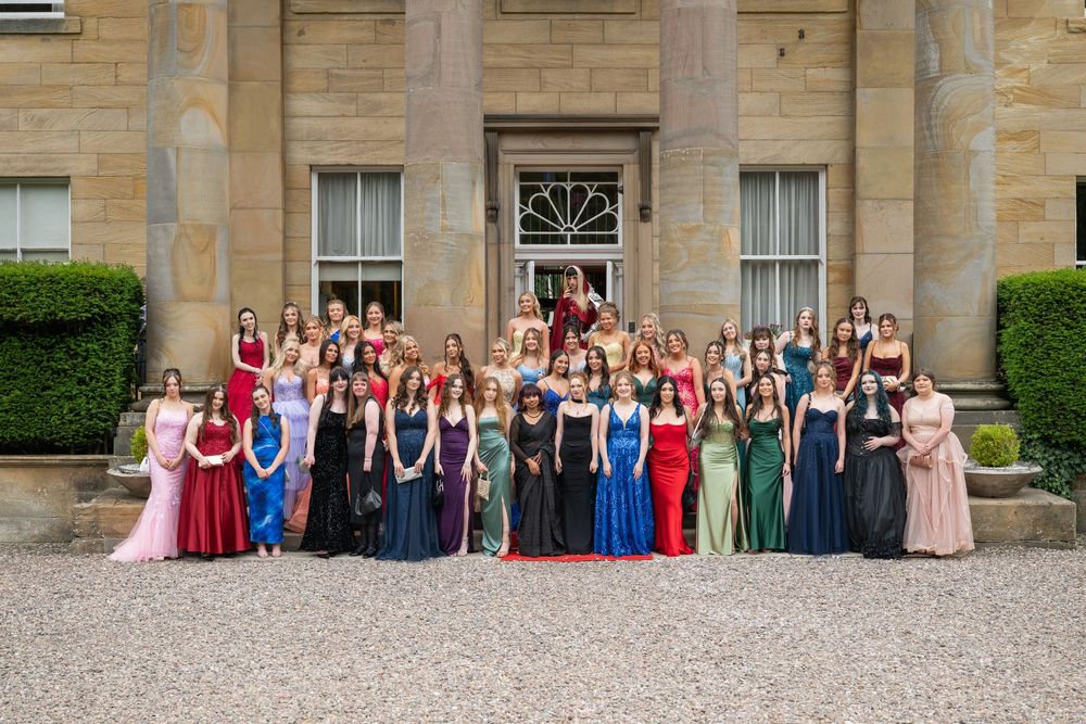 Large formal group photo in front of Balbirnie House  with classical architecture.