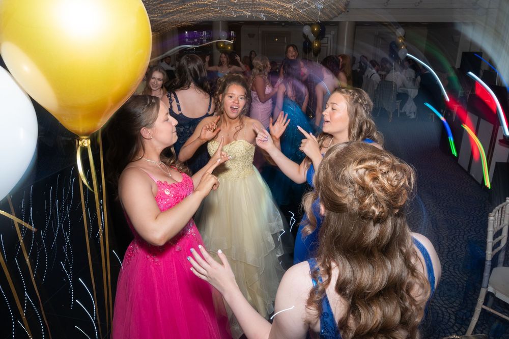 Energetic dance floor scene with colorful lighting at a formal celebration.