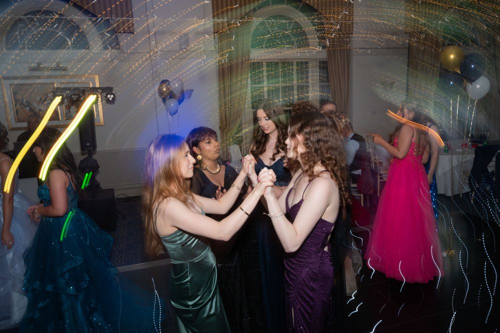 Dynamic dance floor moments captured with motion blur at a formal celebration.