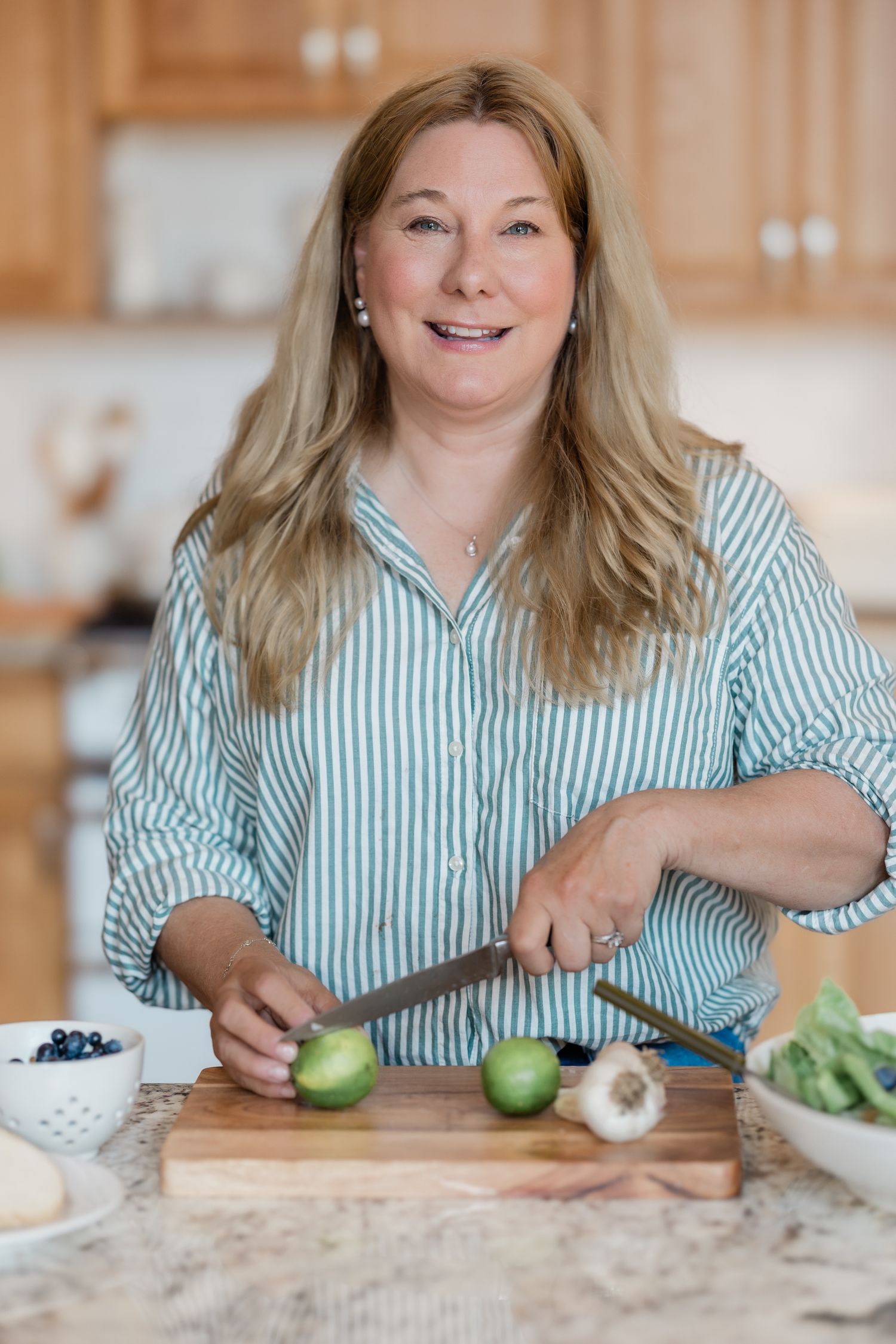 Author poses with branded props to showcase her business easily while cooking. Betsy Rand Portraits is her branding photographer.