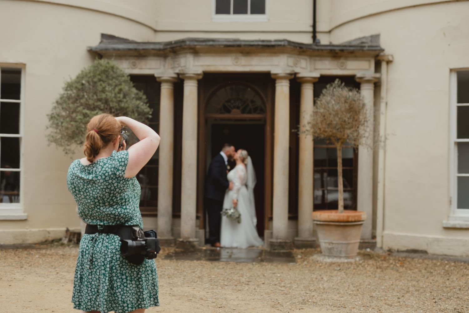 A photographer taking photos of her clients on their wedding day.