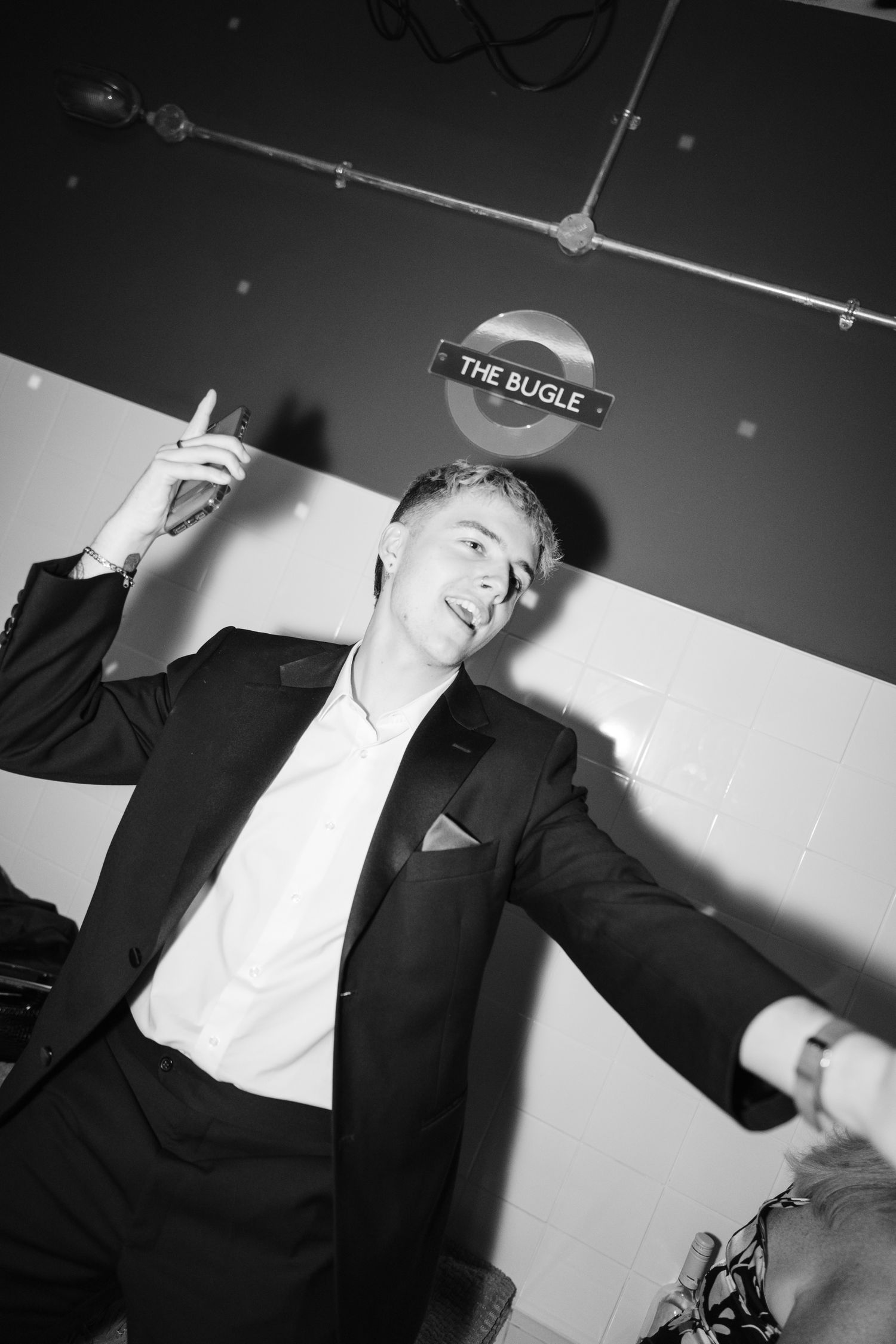 A series of black and white photos showing a person in formal attire making dramatic gestures against a light background.