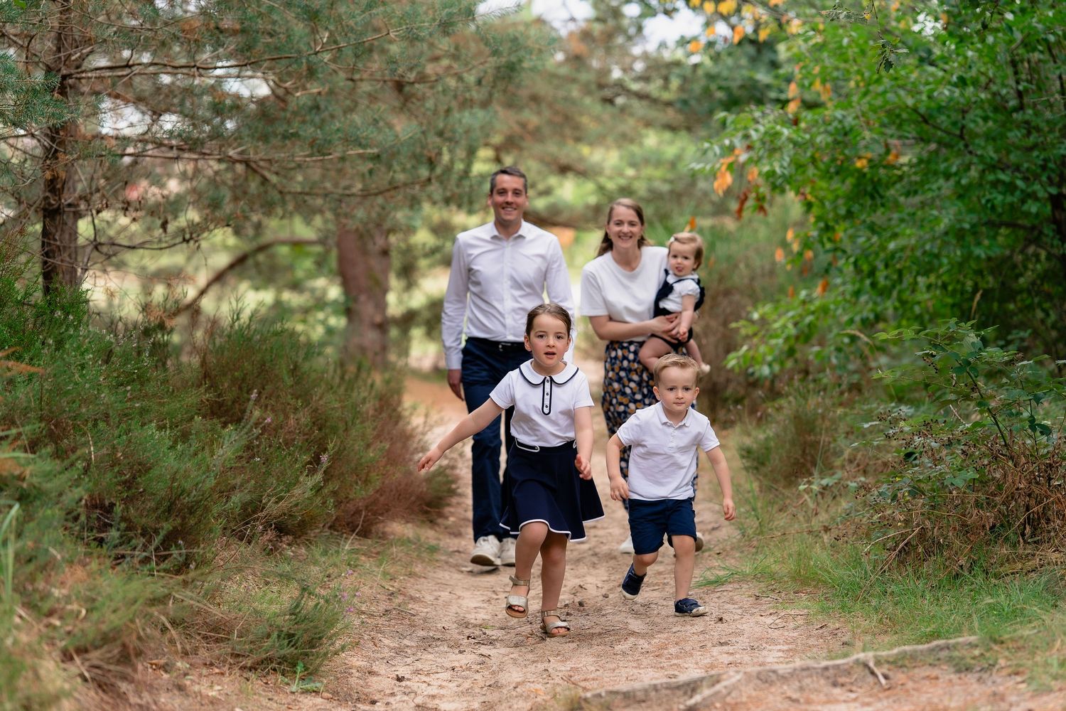 Photo de famille courant dans la foret durant un reportage famille