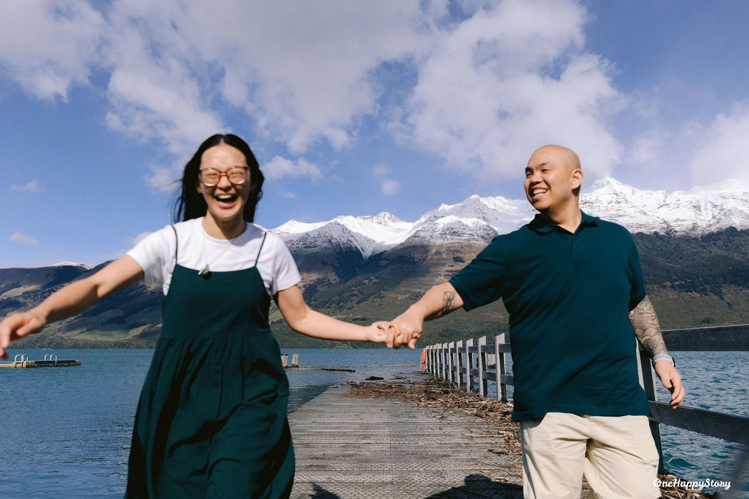 Couple walking hand in hand by the lake during their Glenorchy pre-wedding shoot in New Zealand.