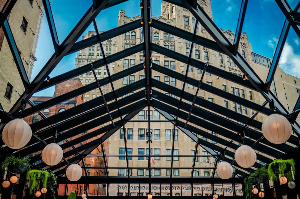Modern glass ceiling architecture with hanging paper lanterns creates an elegant indoor atrium space.