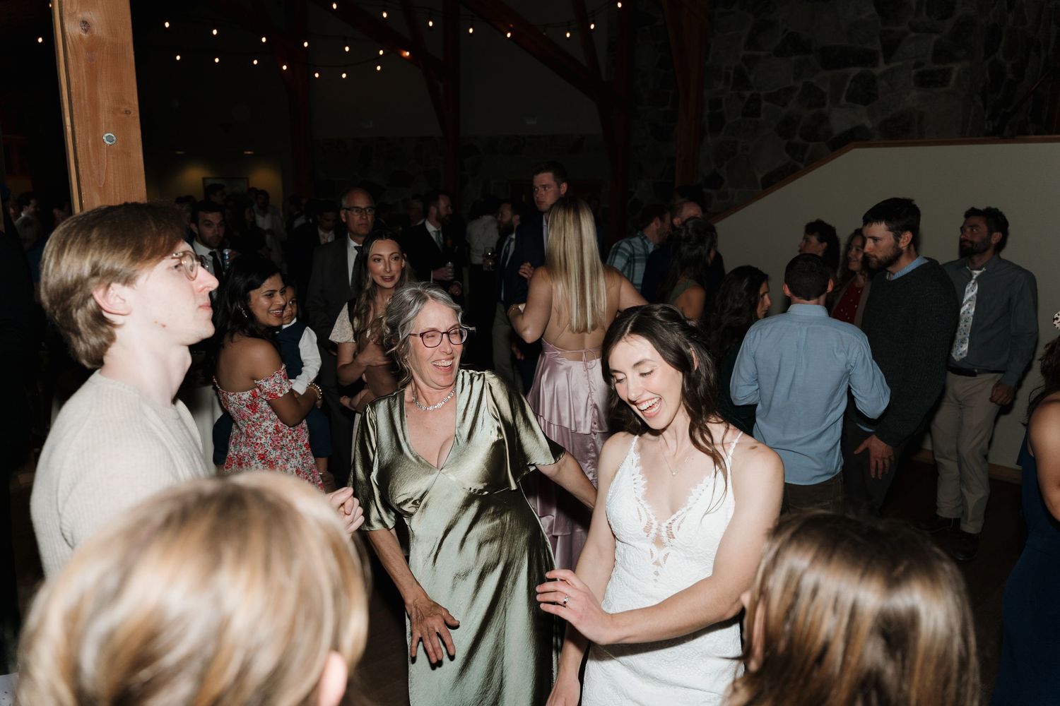 People dancing and socializing at a dimly lit party or reception venue.