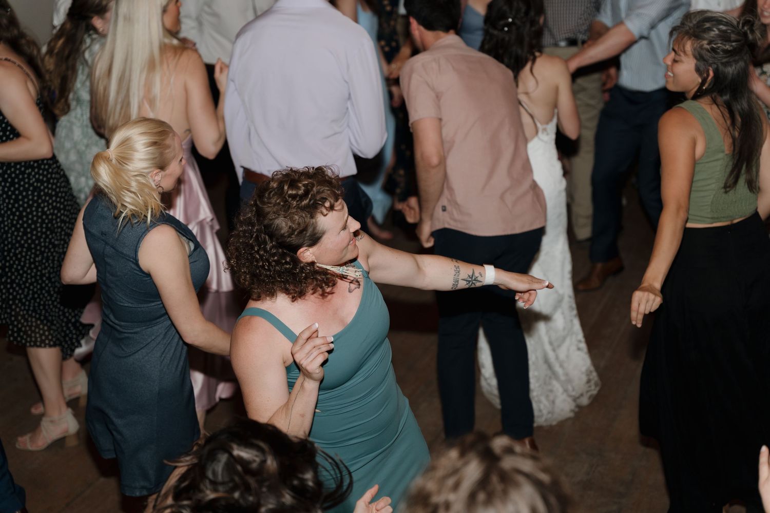 Couples dancing together on a dark dance floor at a social gathering or celebration event.