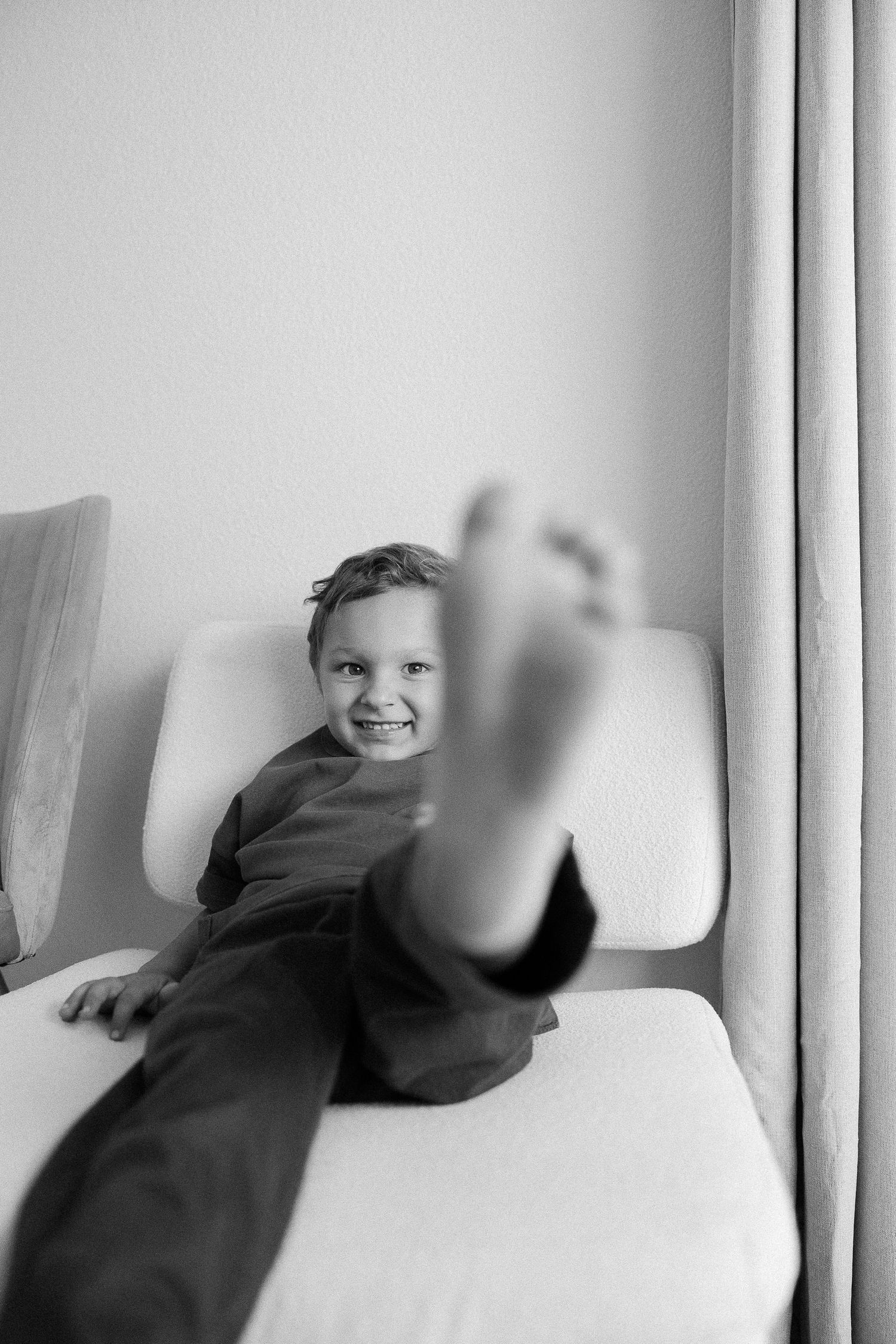 A series of black and white photos showing two people relaxing together on a couch in candid moments.