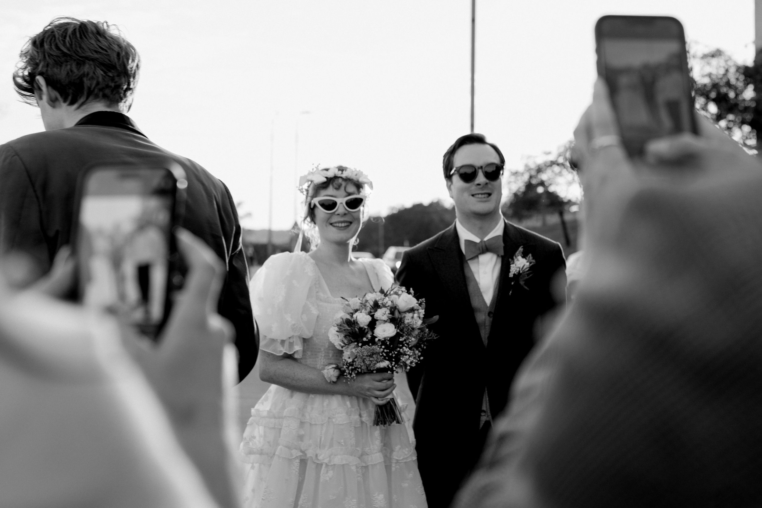 Black and white wedding photo collage showing intimate moments between couples and guests during celebration.