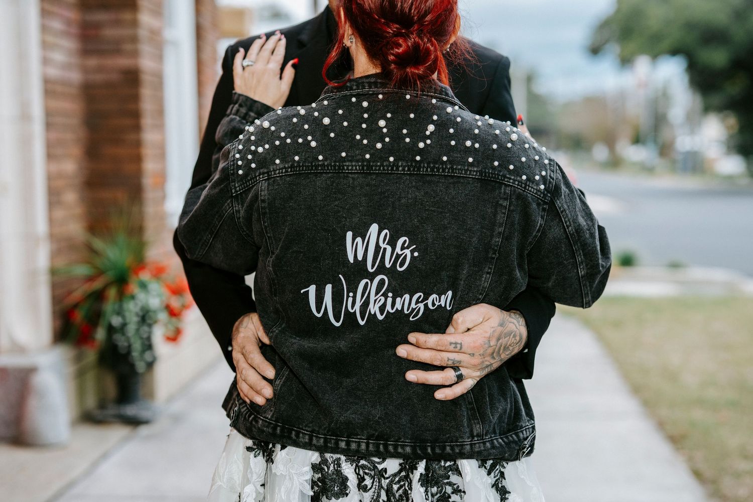 Couple in black outfits poses in the snow during winter engagement photo session.