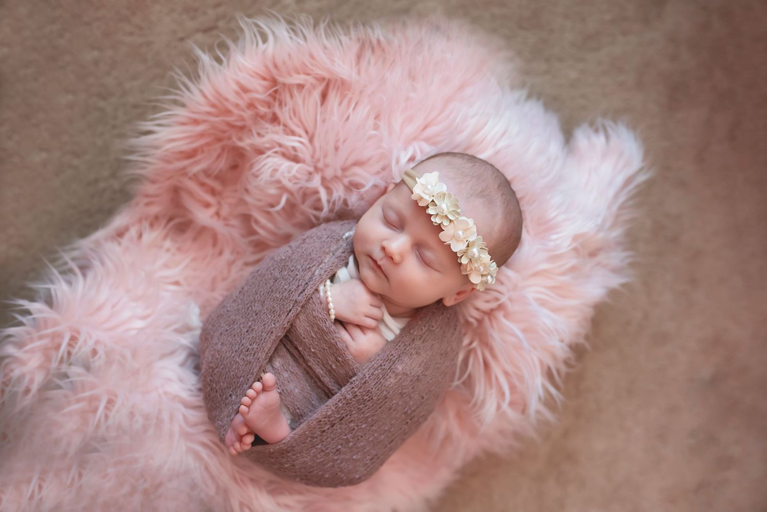 Soft pink fur blanket with delicate details in muted lighting.