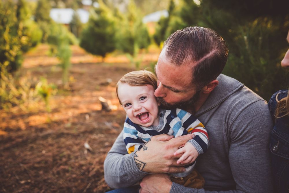 Family sharing playful interactions while sitting together in an outdoor autumn setting.