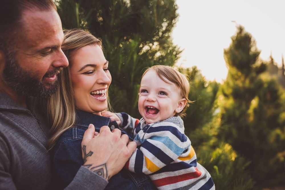A series of candid family moments captured outdoors during golden hour with evergreen trees in the background.