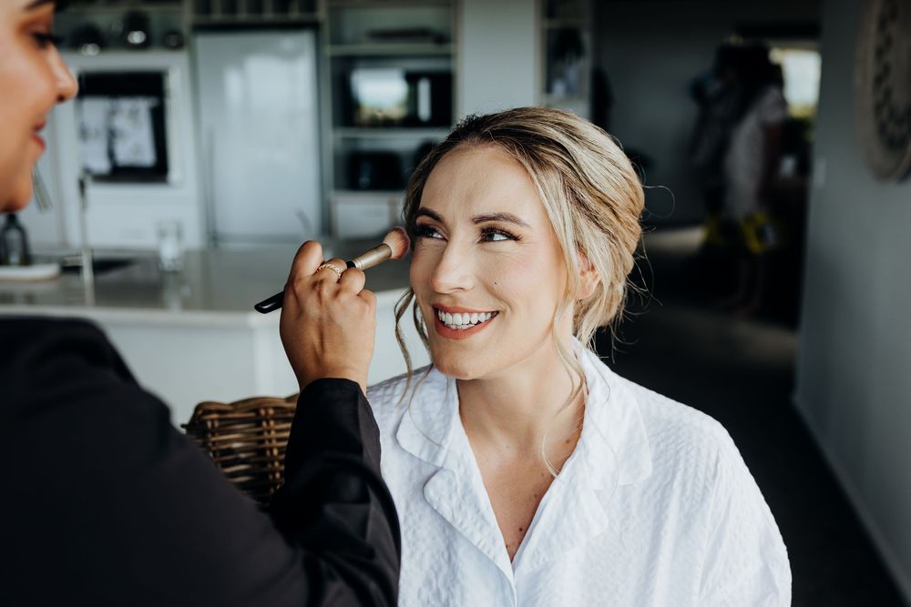 Joyful wedding preparation moments captured in black and white as bride gets ready with her bridal party.