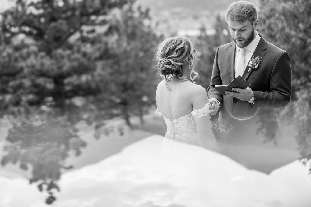A couple shares an intimate moment during their mountain wedding ceremony with scenic views.