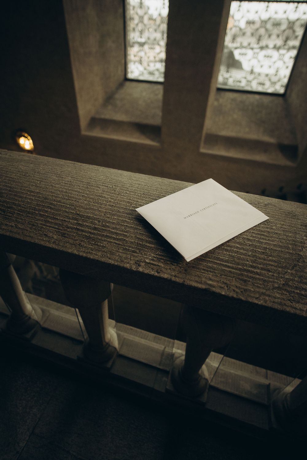 envelope with wedding certificate on the stair of Stockholm City Hall being captured by documentary wedding photographer in Stockholm