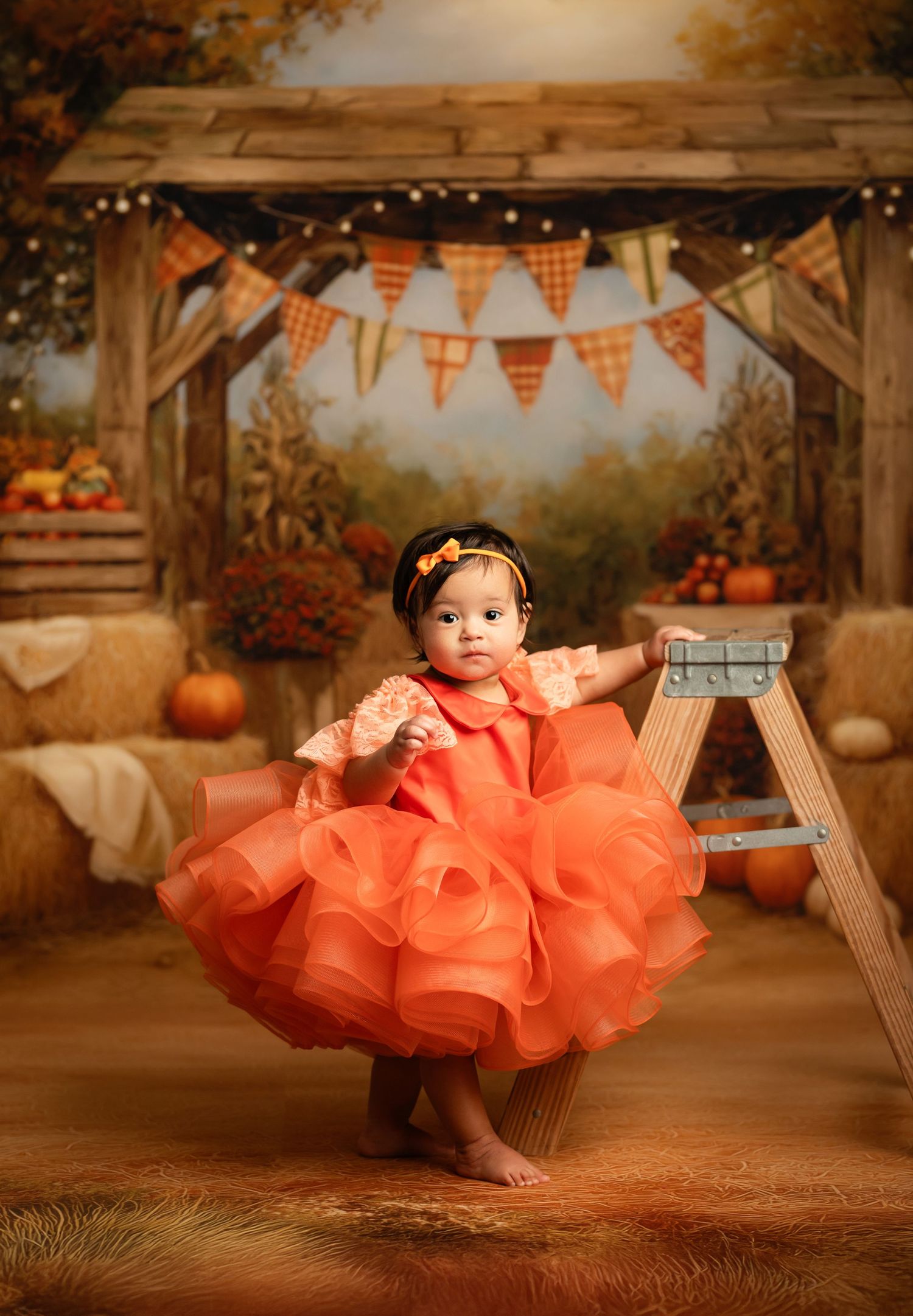 Rustic fall barn setting with orange and white checkered bunting banners and pumpkin decorations creating a cozy autumn atmosphere.