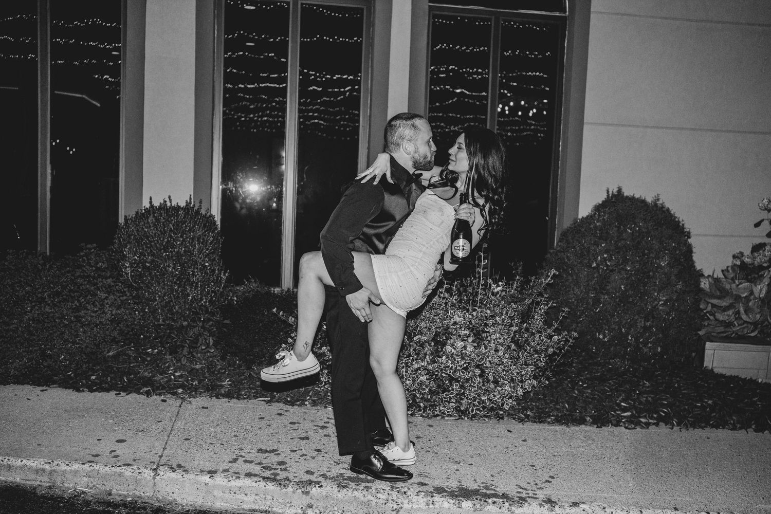A couple's feet shown during a dance on a polished floor at an evening wedding celebration.
