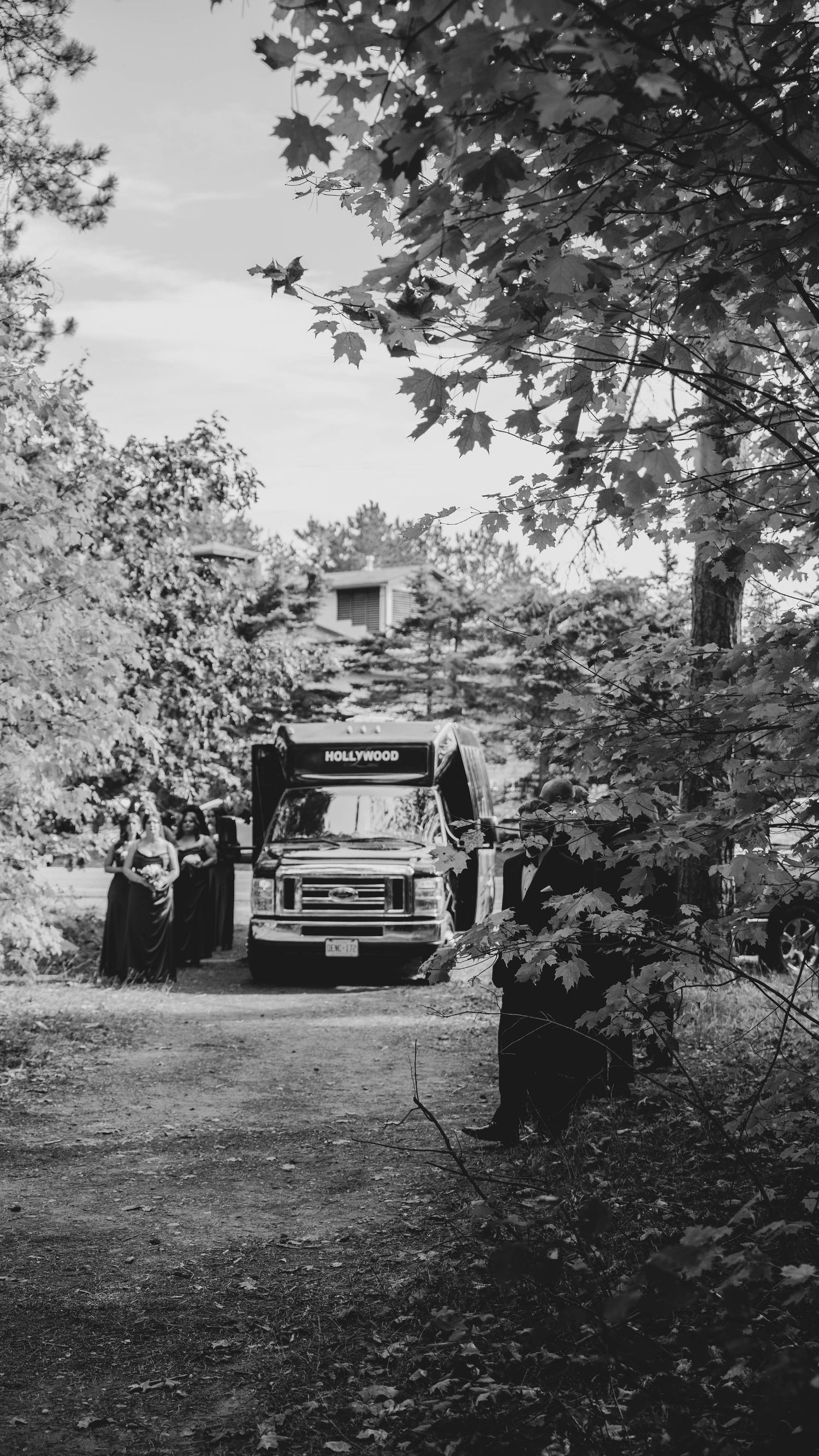 Black and white photo series of a vintage truck parked among trees and foliage in a rural setting.