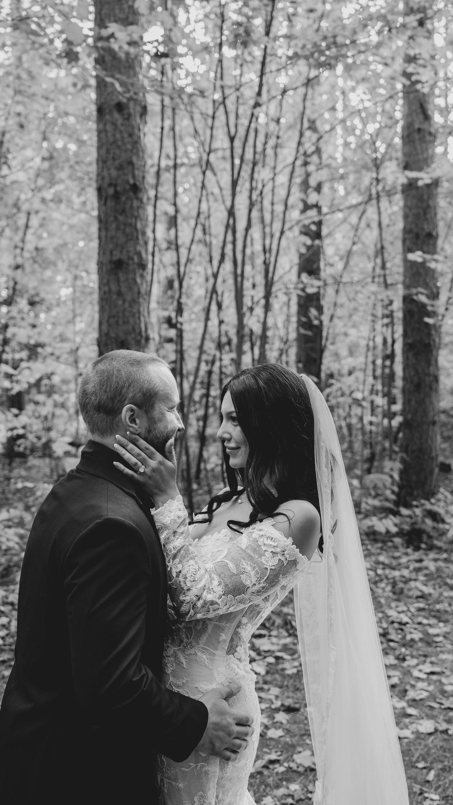 Romantic wedding couple embraces in a serene autumn forest setting.